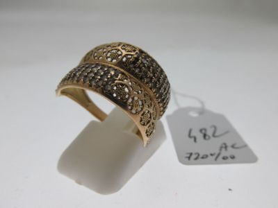 gros plan d'une bague sur une surface blanche avec une étiquette de prix
