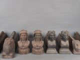 plusieurs petits bustes sculptés, de formes et de tailles variées, posés sur une table