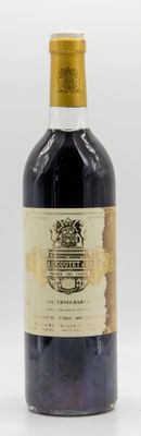 une vieille bouteille de vin posée sur une table blanche