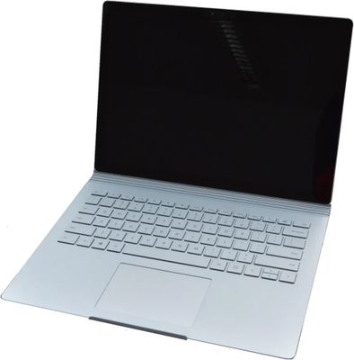 une image montrant un gros plan d'un ordinateur portable posé sur une surface blanche