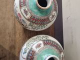 two vases that are sitting on a wooden shelf
