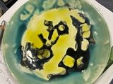 une assiette sur laquelle est peint un smiley, posée sur une table