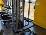 a gym room with a row of exercise machines in it