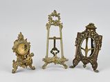 trois horloges miniatures sont posées les unes à côté des autres sur une surface blanche