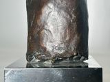 statue of a hand holding a cigarette on a metal stand