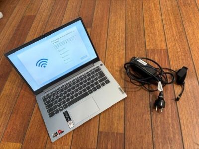 a laptop computer sitting on the floor next to a charger