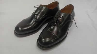 une paire de chaussures noires posée sur une surface blanche