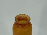 a yellow vase with a bird on it sitting on a white surface