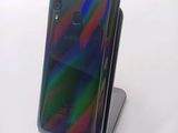 a close up of a cell phone on a stand on a white surface