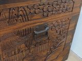 a wooden box with carvings on it on a wooden floor
