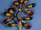 a gold brooch with red, green, and yellow beads