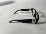 sunglasses on a white surface with a black frame and silver trim