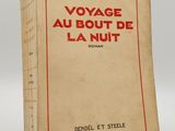 un vieux livre posé sur une table à côté d'un mur blanc