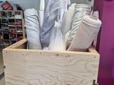 a wooden box with a bunch of cloths inside of it