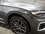a grey car parked in a showroom with a checkered floor