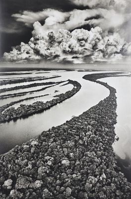 black and white photograph of a river with rocks in the middle