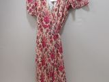 une robe rose à fleurs suspendue à un cintre accroché au mur