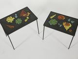 two small tables with colorful designs on them sitting on a white surface