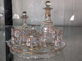 un plateau en verre sur lequel sont posés une carafe en verre et un service de verres