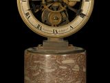 a clock that is sitting on top of a marble stand