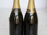 two bottles of champagne sitting on a marble table