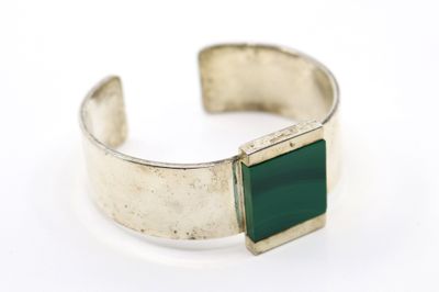 un gros plan sur un bracelet en argent orné d'une pierre verte