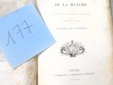 un livre sur lequel est collé un autocollant bleu, à côté d'un bout de papier