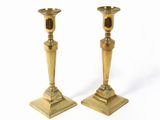 deux bougeoirs dorés sur fond blanc