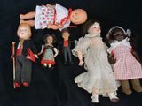 a lot of dolls that are sitting together on a black background