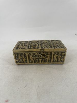 an antique brass box with carvings on it