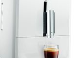 La machine à café Jura est blanche et contient une tasse de café.
