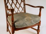 une chaise en bois sur laquelle est posé un coussin vert