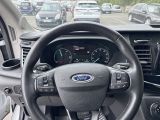 a steering wheel and dashboard of a car in a parking lot