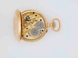 a close up of a pocket watch on a white surface