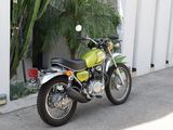 a green motorcycle parked in front of a white building