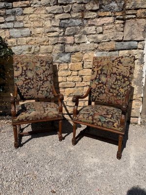 two chairs sitting next to each other in front of a brick wall