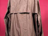 the back of a jacket on a mannequin stand against a pink background