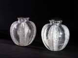 two glass vases that are sitting on a black surface