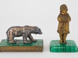 une statue représentant un garçon et un ours, posée sur un socle en marbre