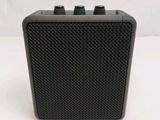 an image of a black speaker sitting on top of a white table