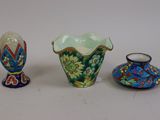 trois vases de couleurs différentes posés les uns à côté des autres sur une surface blanche