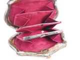 a pink purse that has a silver handle inside of it