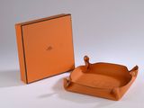 an orange leather tray with a handle and a box