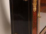 a black and gold cabinet with a mirror on top of it