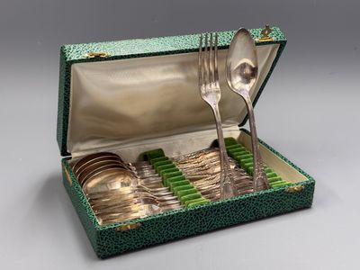a green box with silverware in it on a table