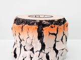 un vase blanc et orange posé sur une surface blanche