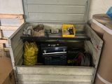 une boîte à outils contenant des outils, dans un garage
