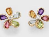une paire de boucles d'oreilles composées de pierres précieuses multicolores et d'une fleur en or