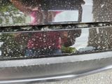 a woman taking a picture of herself in the reflection of a car window