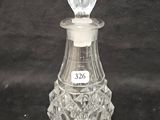 an antique glass perfume bottle with a stopper on a black background